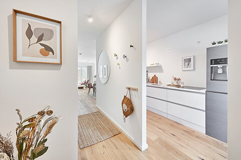 Blick durch den Raum neben der Küche ins Wohnzimmer der zweiten Musterwohnung des Neubauprojekts Constanze im ConstantinQuartier. Die offene Küche ist durch eine Trennwand abgeteilt.