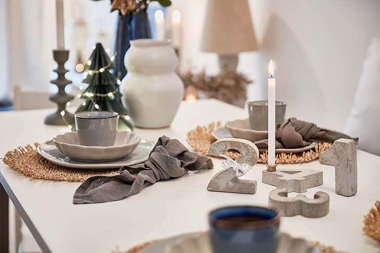 Geschmückter Weihnachtstisch mit brennender Kerze im Muster-Stadthaus des Neubauprojekt Constanze.